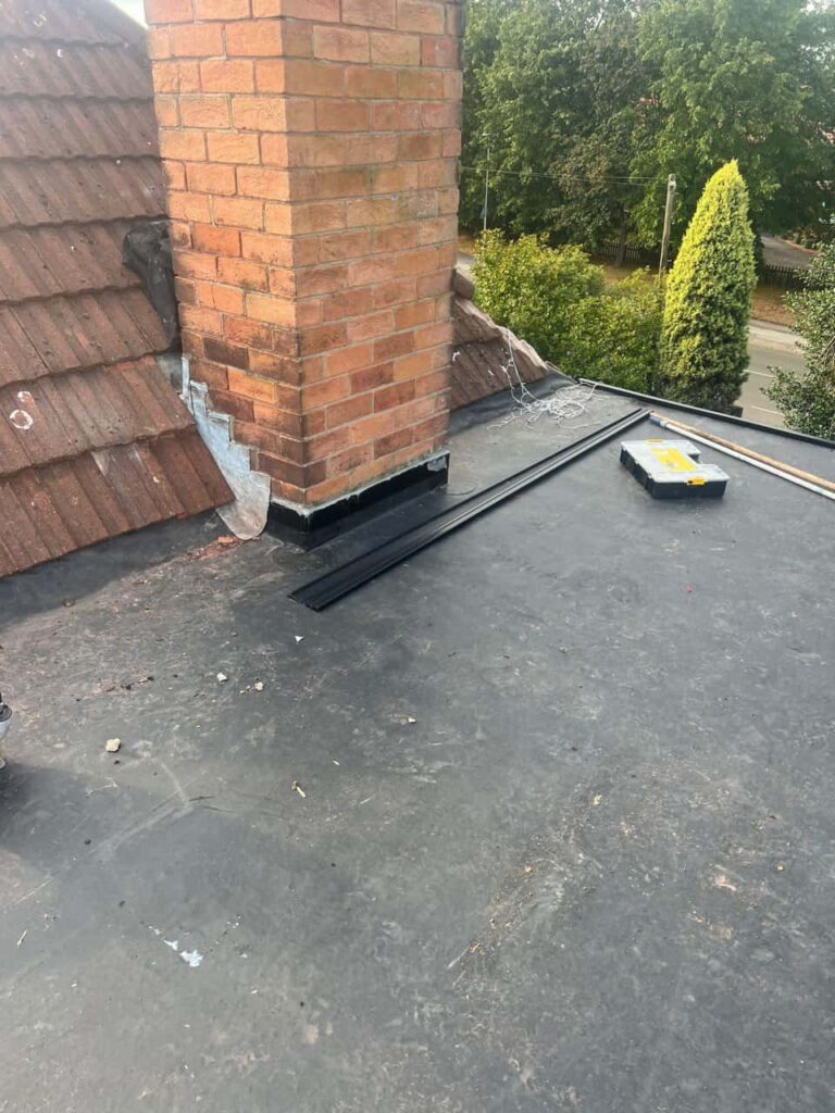 This is a photo of a flat roof which has just been repaired, there is also a chimney stack and some leadwork has also been dressed. Works carried out by LJ Roofing Criklade